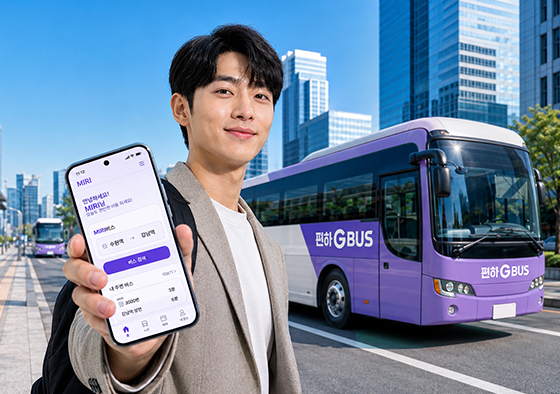 경기편하G버스를 배경으로 MiRi앱 화면을 보여주고 있는 청년
