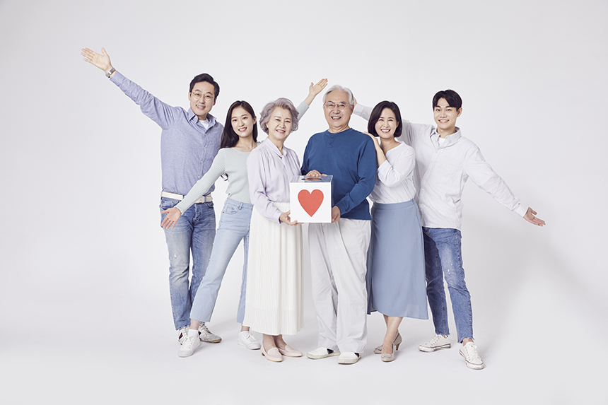 남녀노소 무리가 선채로 자유로운 자세를 취하며 웃고있는 모습