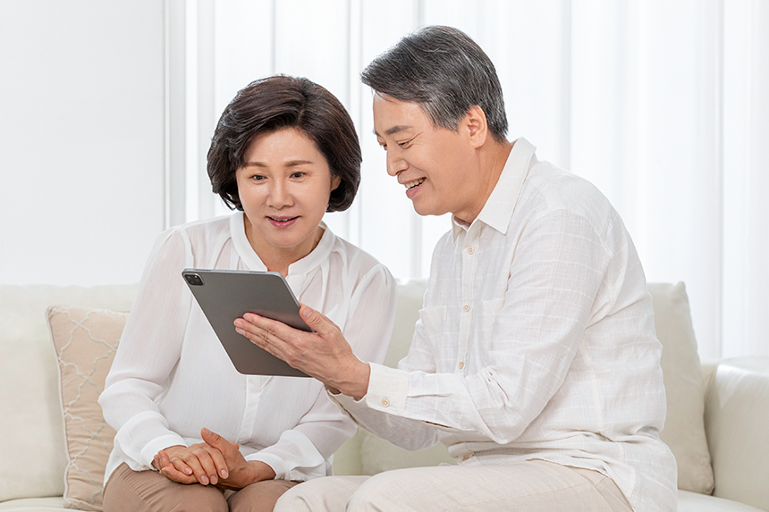 태블릿pc를 확인하고 있는 중장년 부부의 모습