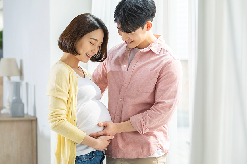 임신한 아내의 배를 받쳐주고 있는 남편