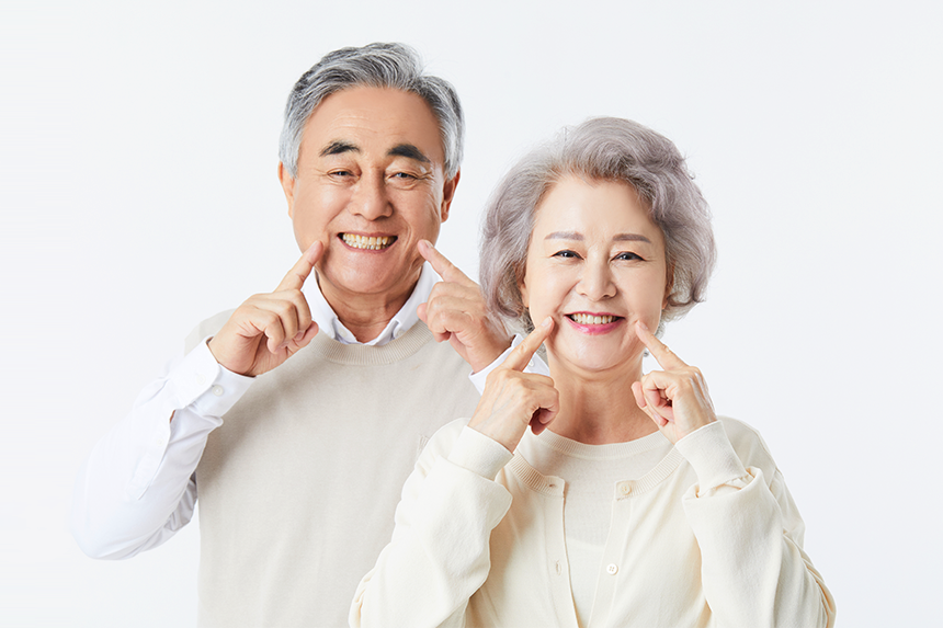 이를 드러내며 활짝 웃고 있는 노년 부부