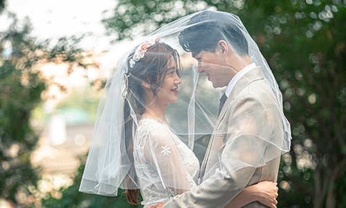 면사포를 나눠 쓴 신부와 마주본 신랑