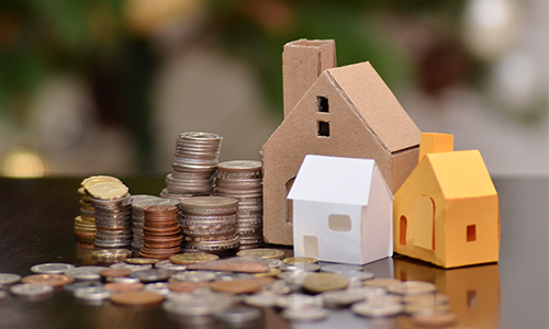 잔뜩 쌓인 동전과 종이로 만든 집