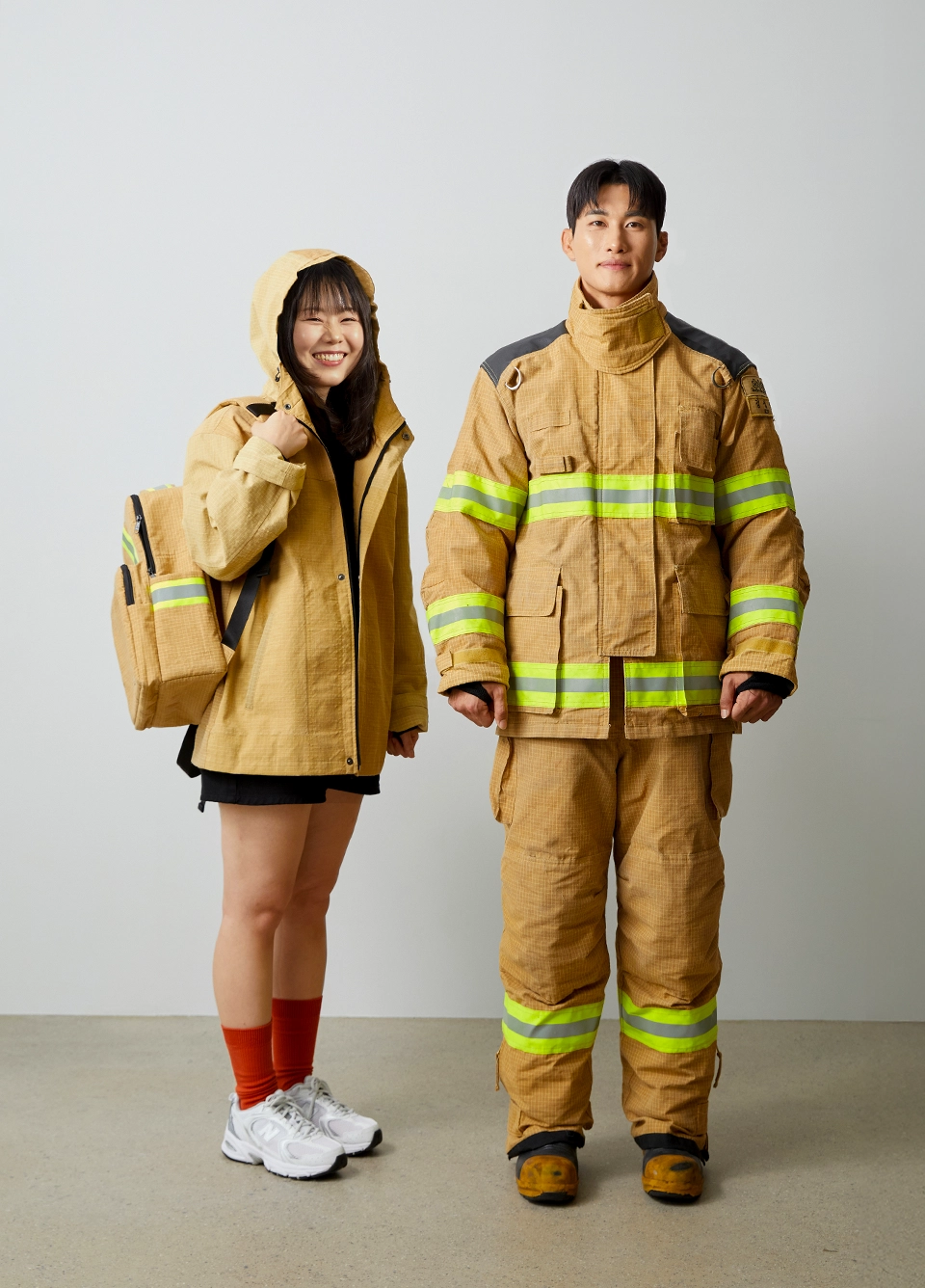 자켓,백팩 샘플 이미지 : 자켓과 백팩을 맨 여성과, 방화복을 입은 남성 소방수 전신샷